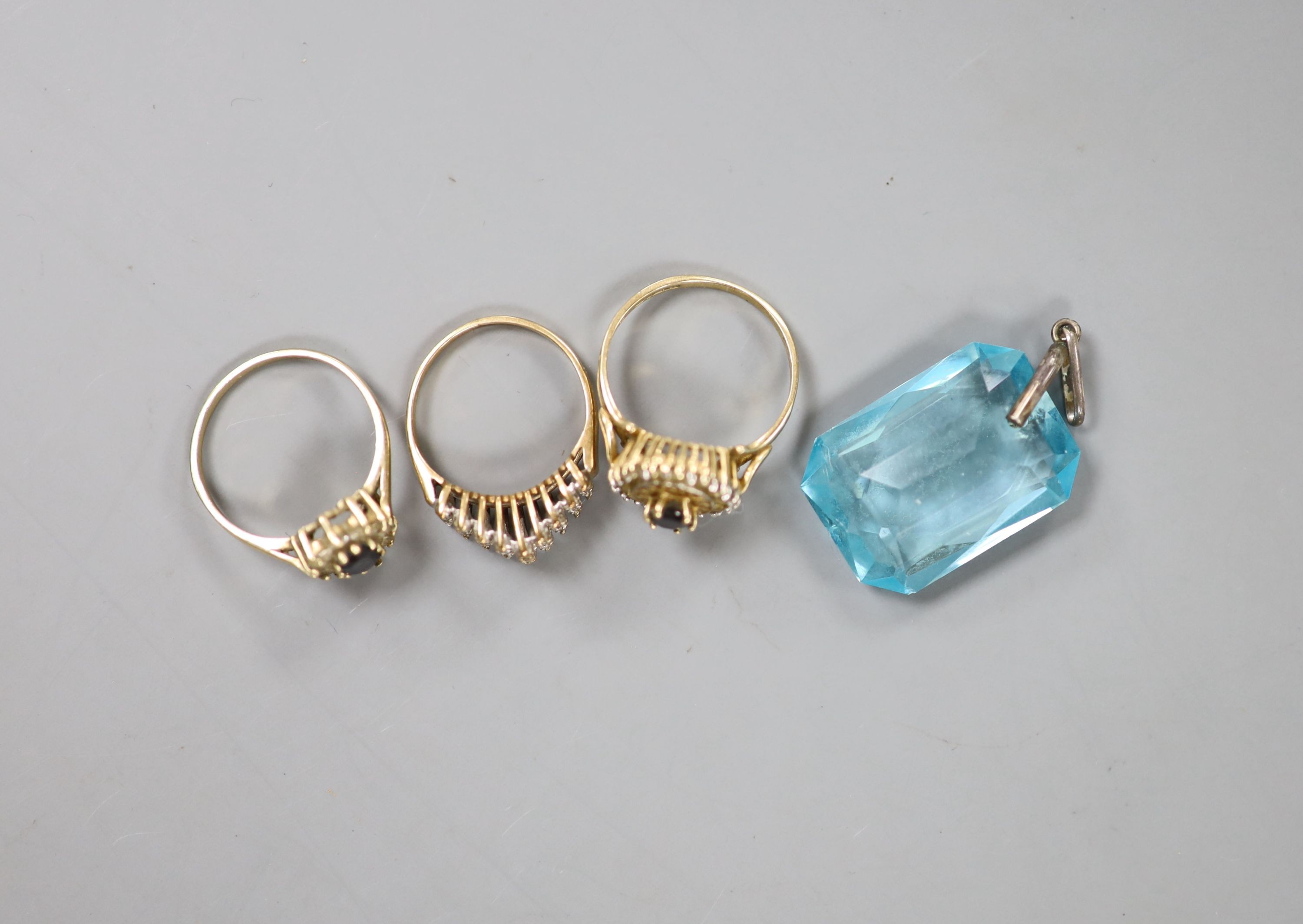 Three assorted modern 9ct gold and gem set rings, gross 6.5 grams and a paste pendant.
